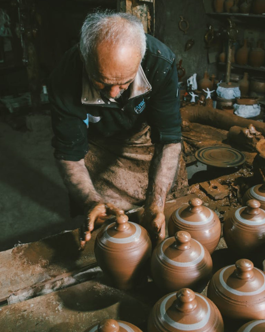 Man working with clay pots in a pottery studio