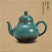 Teal ceramic teapot on a light gray background