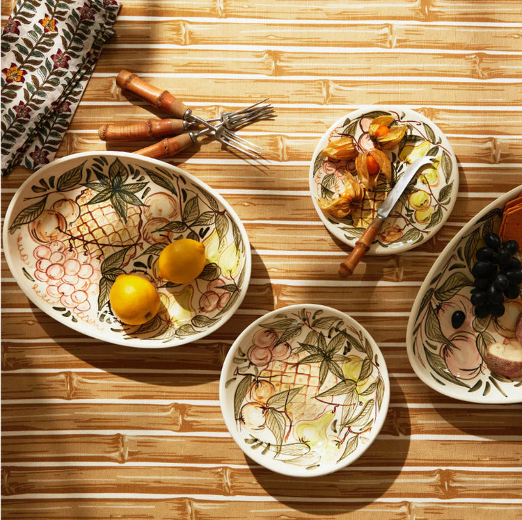 Decorative ceramic bowls with fruit designs on a wooden surface