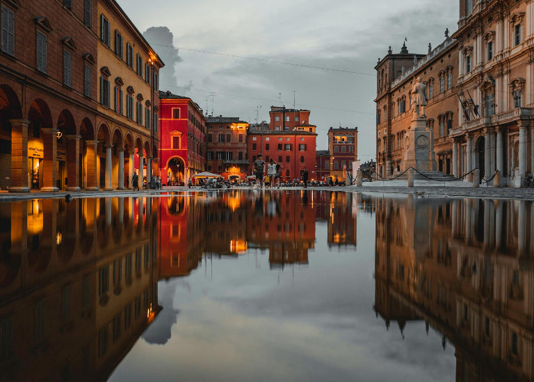 Reflection of historic buildings in a water basin with a cloudy sky.
