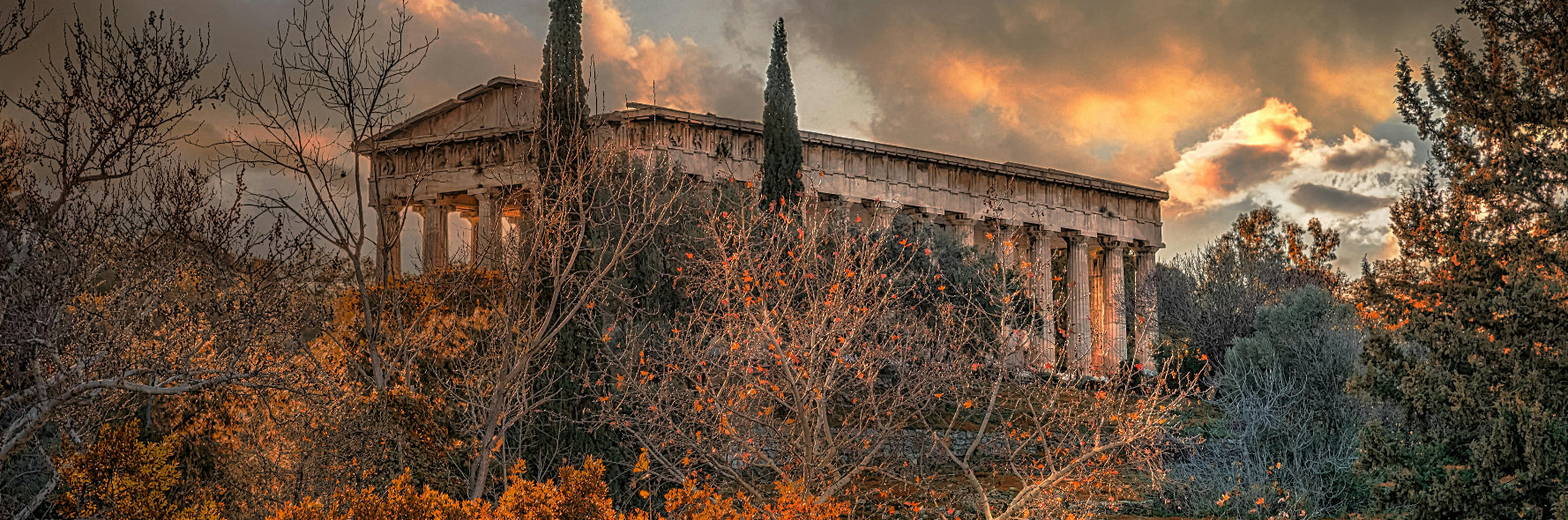 Ancient temple surrounded by trees with a dramatic sky