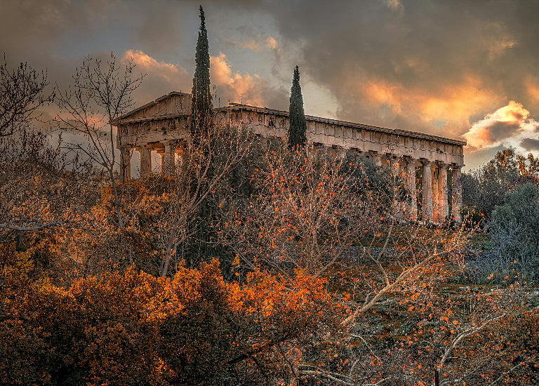 Ancient temple surrounded by trees with a dramatic sky