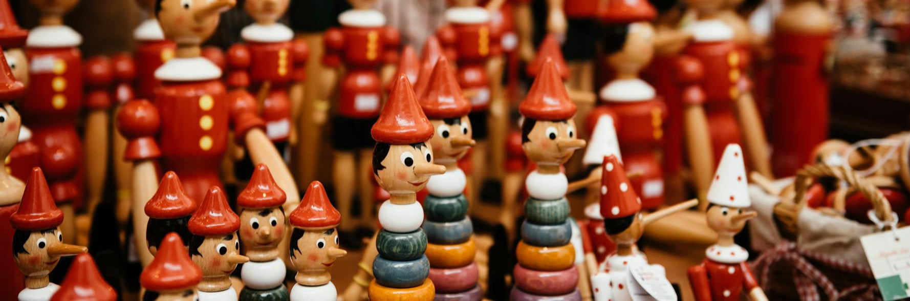 Collection of small figurines with red hats and colorful bodies on a blurred background